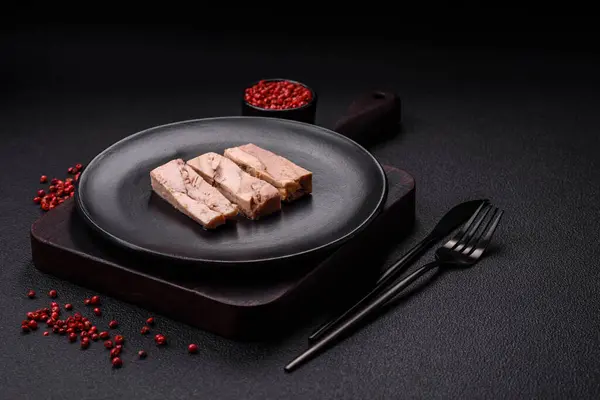 Delicious canned dietary tuna meat with salt, spices and oil on a dark concrete background