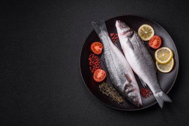 Taze çiğ okyanus levreği balığı. Tuz, baharat ve çimento arka planda bitkilerle birlikte.