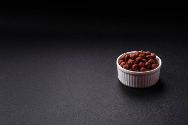 Lezzetli fındık bütün, çiğ, kabuksuz, koyu beton bir arka planda. Kalori bileşeni