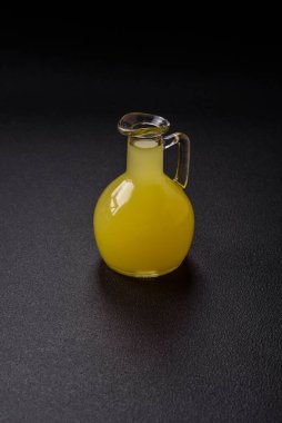 Alkolik sarı limoncello içer. Küçük bardakta, koyu beton arka planda.