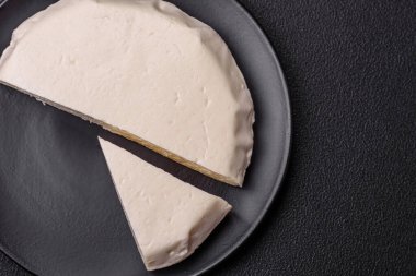 Koyu beton bir arka planda inek sütü veya koyun sütünden taze taze, lezzetli beyaz peynir.