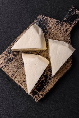 Koyu beton bir arka planda inek sütü veya koyun sütünden taze taze, lezzetli beyaz peynir.