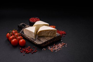 Koyu beton bir arka planda inek sütü veya koyun sütünden taze taze, lezzetli beyaz peynir.