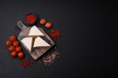 Koyu beton bir arka planda inek sütü veya koyun sütünden taze taze, lezzetli beyaz peynir.