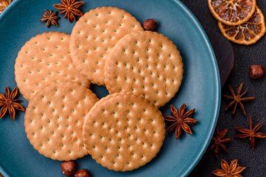 Koyu beton arka planda kremalı yuvarlak atıştırmalık kurabiyeler. Kahvaltıda tatlı.