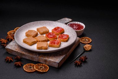 Fıstık ezmeli lezzetli, besleyici sandviçler, koyu beton arka planda çilek reçeli.