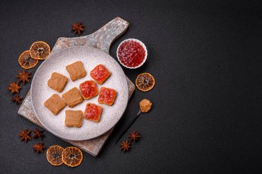 Fıstık ezmeli lezzetli, besleyici sandviçler, koyu beton arka planda çilek reçeli.