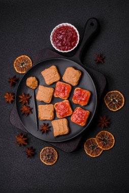 Fıstık ezmeli lezzetli, besleyici sandviçler, koyu beton arka planda çilek reçeli.