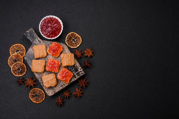 Fıstık ezmeli lezzetli, besleyici sandviçler, koyu beton arka planda çilek reçeli.