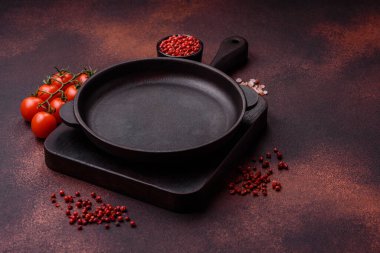 Empty ceramic round plate on dark textured concrete background. Cutlery, preparation for dinner