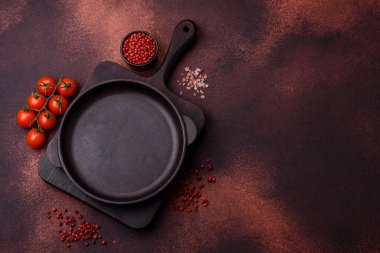 Empty ceramic round plate on dark textured concrete background. Cutlery, preparation for dinner