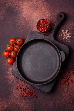 Empty ceramic round plate on dark textured concrete background. Cutlery, preparation for dinner