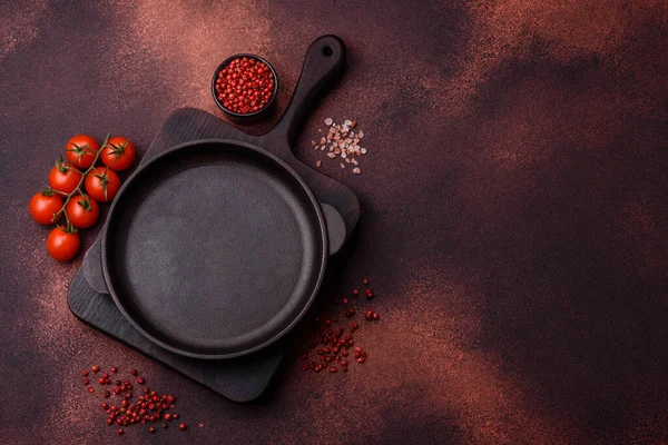 Empty ceramic round plate on dark textured concrete background. Cutlery, preparation for dinner