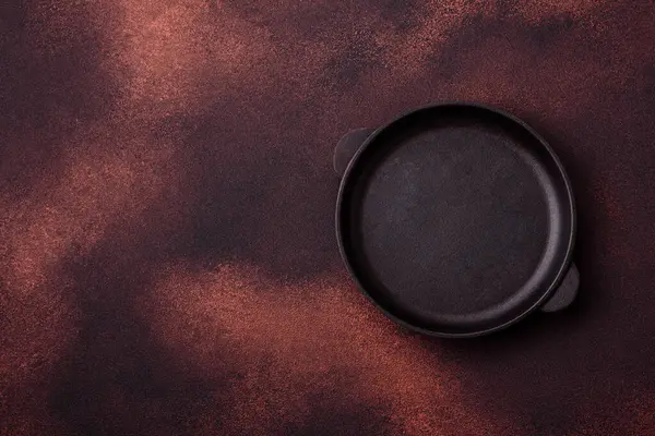 Empty ceramic round plate on dark textured concrete background. Cutlery, preparation for dinner