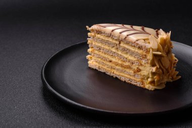 Fındıklı ve kremalı lezzetli pastadan bir parça koyu beton arka planda.