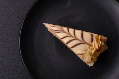 Fındıklı ve kremalı lezzetli pastadan bir parça koyu beton arka planda.