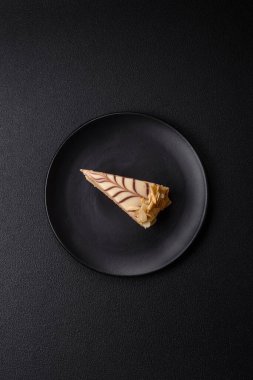 Fındıklı ve kremalı lezzetli pastadan bir parça koyu beton arka planda.