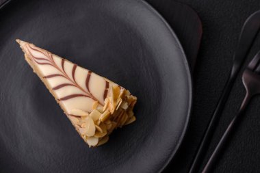 Fındıklı ve kremalı lezzetli pastadan bir parça koyu beton arka planda.