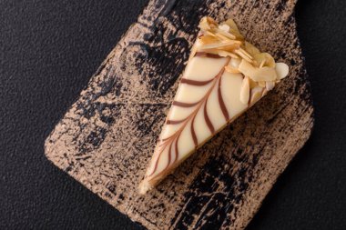 Fındıklı ve kremalı lezzetli pastadan bir parça koyu beton arka planda.