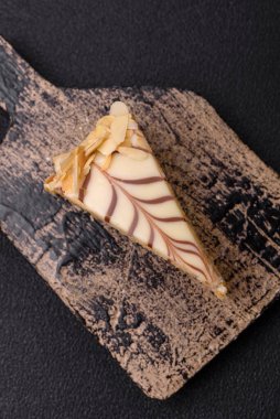 Fındıklı ve kremalı lezzetli pastadan bir parça koyu beton arka planda.