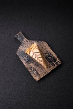 Fındıklı ve kremalı lezzetli pastadan bir parça koyu beton arka planda.