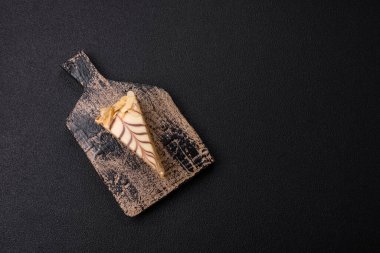 Fındıklı ve kremalı lezzetli pastadan bir parça koyu beton arka planda.