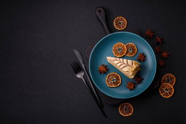 Fındıklı ve kremalı lezzetli pastadan bir parça koyu beton arka planda.