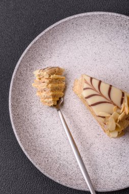 Fındıklı ve kremalı lezzetli pastadan bir parça koyu beton arka planda.