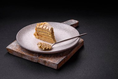 Fındıklı ve kremalı lezzetli pastadan bir parça koyu beton arka planda.