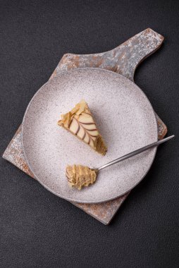 Fındıklı ve kremalı lezzetli pastadan bir parça koyu beton arka planda.