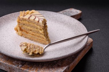 Fındıklı ve kremalı lezzetli pastadan bir parça koyu beton arka planda.