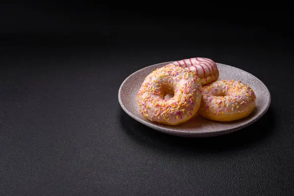 Delicious sweet bright donuts with cream on a plain background. Holiday table attribute