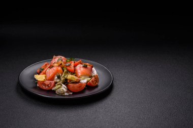 Somon, domates, salatalık, salatalık, otlar, kabak çekirdekleri, seramik tabakta tuz ve baharatlarla dolu lezzetli bir salata.