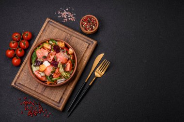 Somon, domates, salatalık, salatalık, otlar, kabak çekirdekleri, seramik tabakta tuz ve baharatlarla dolu lezzetli bir salata.