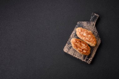 Lezzetli taze kıymalı balık pirzolası. Esmer arka planda baharatlar ve otlarla birlikte.