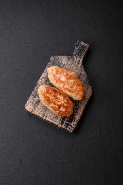 Lezzetli taze kıymalı balık pirzolası. Esmer arka planda baharatlar ve otlarla birlikte.