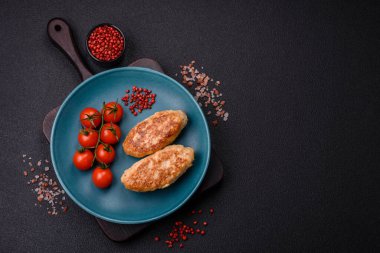 Lezzetli taze kıymalı balık pirzolası. Esmer arka planda baharatlar ve otlarla birlikte.