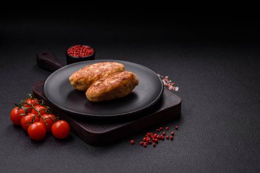 Lezzetli taze kıymalı balık pirzolası. Esmer arka planda baharatlar ve otlarla birlikte.