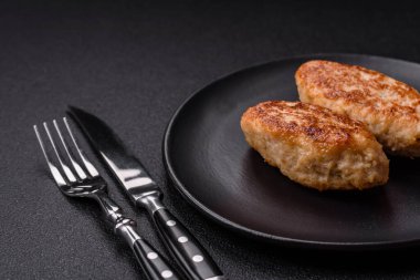 Lezzetli taze kıymalı balık pirzolası. Esmer arka planda baharatlar ve otlarla birlikte.