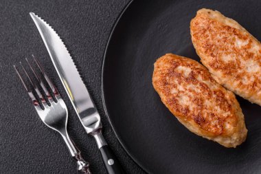 Lezzetli taze kıymalı balık pirzolası. Esmer arka planda baharatlar ve otlarla birlikte.