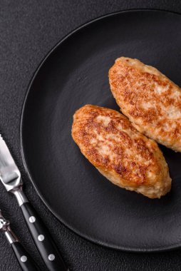 Lezzetli taze kıymalı balık pirzolası. Esmer arka planda baharatlar ve otlarla birlikte.