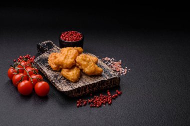 Delicious fresh crispy chicken nuggets on a dark concrete background. Unhealthy food, fast food