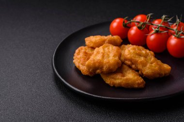 Delicious fresh crispy chicken nuggets on a dark concrete background. Unhealthy food, fast food