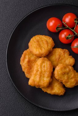 Delicious fresh crispy chicken nuggets on a dark concrete background. Unhealthy food, fast food