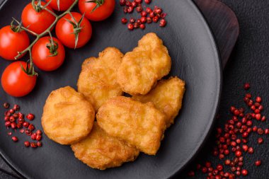 Delicious fresh crispy chicken nuggets on a dark concrete background. Unhealthy food, fast food