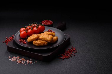 Delicious fresh crispy chicken nuggets on a dark concrete background. Unhealthy food, fast food