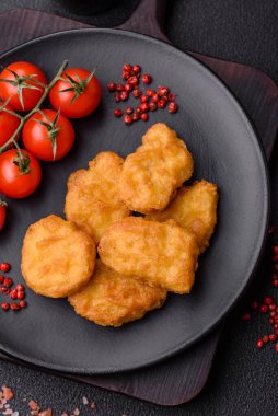Delicious fresh crispy chicken nuggets on a dark concrete background. Unhealthy food, fast food