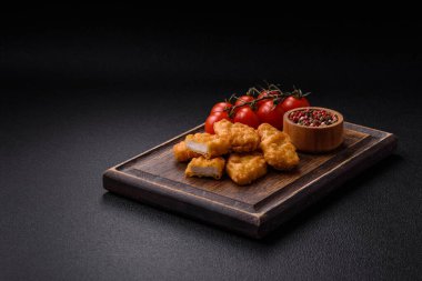 Delicious fresh crispy chicken nuggets on a dark concrete background. Unhealthy food, fast food