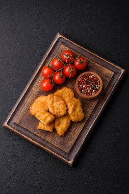 Delicious fresh crispy chicken nuggets on a dark concrete background. Unhealthy food, fast food