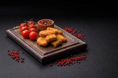 Delicious fresh crispy chicken nuggets on a dark concrete background. Unhealthy food, fast food